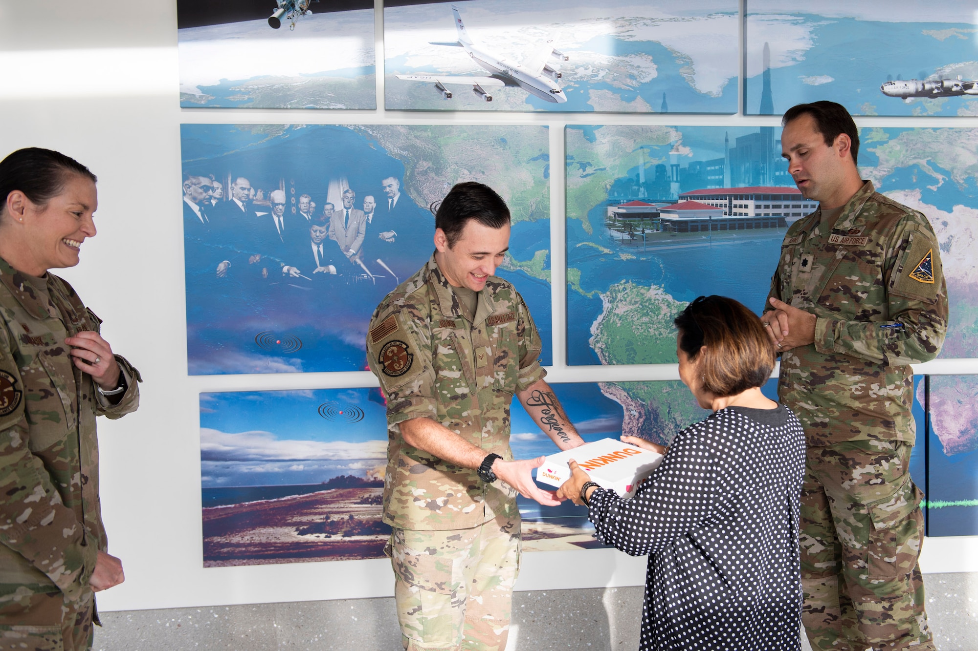 Jade Black, chief of Community Services for the 45th Force Support Squadron, presents a box of donuts to Senior Airman Tyler Johnson, a subsurface operations manager at the 22nd Surveillance Squadron, Patrick SFB, Fla., as a small token of her gratitude after Johnson received a coin from Lt. Col. Brett Kuhrt, 45th FSS commander.  Tyler was lauded for rendering aid to a woman and her child who were involved in an auto accident near the base April 13, 2023.  Also pictured is Lt. Col. Christine Lukasik (left), 22nd SURS commander.  (U.S. Air Force photo by Matthew S. Jurgens)