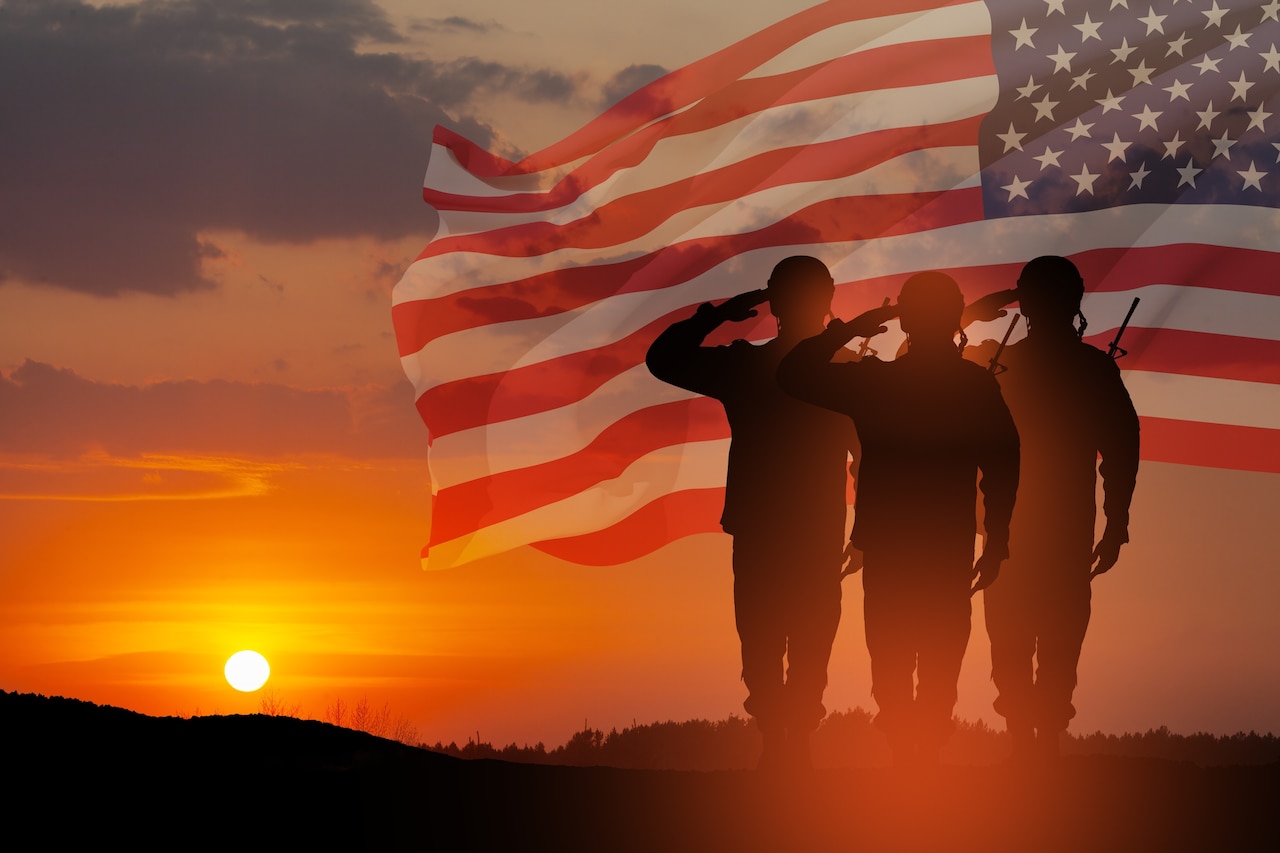 Three military figures salute in front of a flag against a golden sunny background.