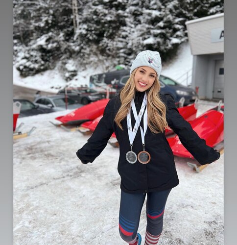 Emily Bradley displaying a silver and bronze medal after completing two races in Igls, Austria, January 2023.