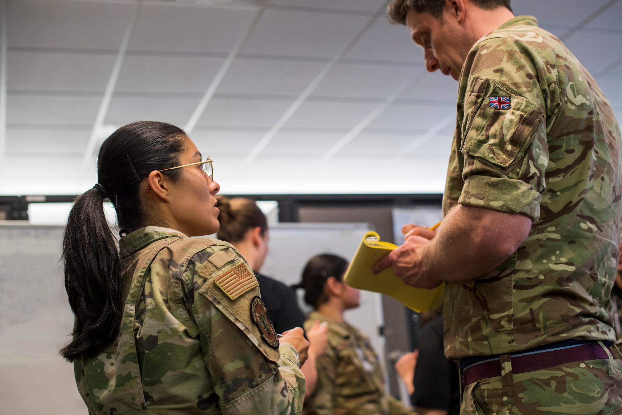 A U.S. service member collaborates with a service member from the Royal Air Force during SPACE FLAG 23-2 at Schriever Space Force Base, Colorado, April 27, 2023. SPACE FLAG 23-2 was the largest exercise iteration to date, involving 250 participants. It was also the most complex integration of cyber warfare, the largest integration of coalition partners ever at a SPACE FLAG exercise, and the first SPACE FLAG exercise to feature live-fire space electronic warfare. (U.S. Space Force photo by Judi Tomich)