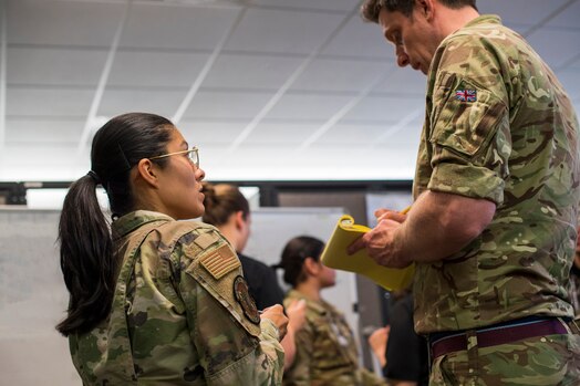  A U.S. service member collaborates with a service member from the Royal Air Force during SPACE FLAG 23-2 at Schriever Space Force Base, Colorado, April 27, 2023. SPACE FLAG 23-2 was the largest exercise iteration to date, involving 250 participants. It was also the most complex integration of cyber warfare, the largest integration of coalition partners ever at a SPACE FLAG exercise, and the first SPACE FLAG exercise to feature live-fire space electronic warfare. (U.S. Space Force photo by Judi Tomich)
