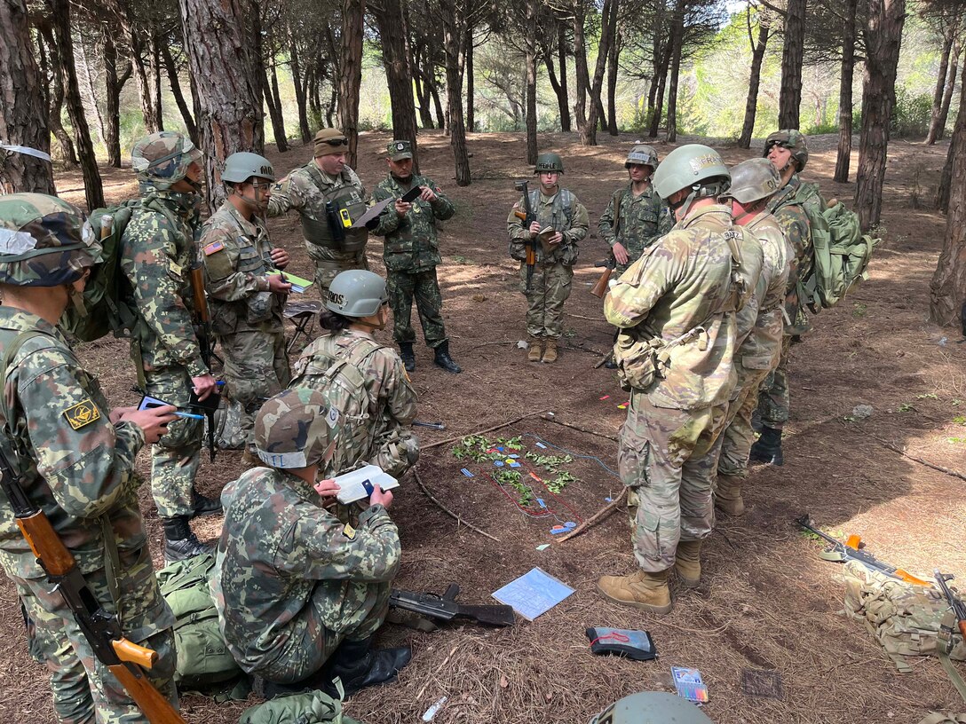New York and New Jersey Army National Guard officer candidates and Albanian officer cadets listen during a mission briefing on April 12, 2023, near Rrogozhine-Kryevidh, Albania. The officer candidates participated in two weeks of training with Albanian officer cadets April 10-24 as part of a State Partnership Program exchange.