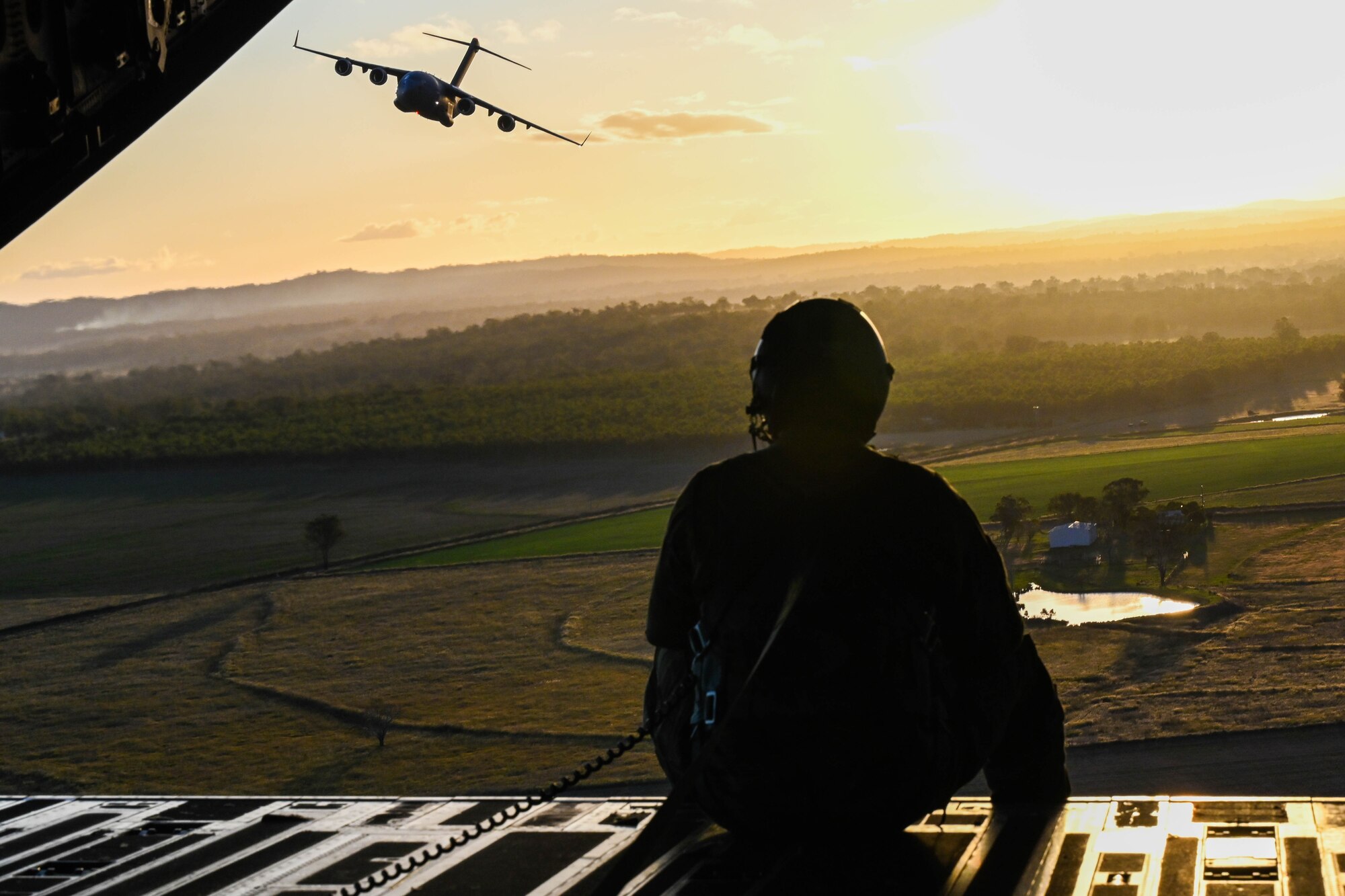 U.S. Air Force Tech Sgt. Joseph Hoffman, 535th Airlift Squadron advance instructor course loadmaster, sits on the ramp of a C-17 Globemaster III during a training flight around the skies of Australia for Global Dexterity 23-1, April 27, 2023. This is the sixth iteration of Exercise Global Dexterity between the U.S. Air Force and our Indo-Pacific partners, the Royal Australian Air Force, and focuses on strengthening our military partnership in the region. The partnership between Australia and the U.S. is vital given the changing strategic environment in the region and demonstrates our commitment to revitalizing our alliances with our two closest allies. (U.S. Air Force photo by Senior Airman Makensie Cooper)