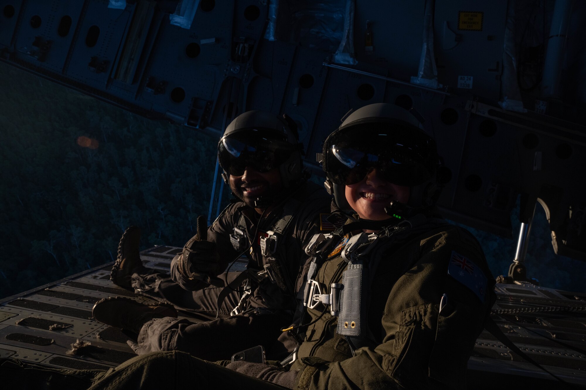 U.S. Air Force Senior Airman Jovanni Banuchi, 535th Airlift Squadron loadmaster, and Royal Australian Air Force Maddy Hardy, No. 36 Squadron loadmaster, sit on the ramp of a C-17 Globemaster III during a training flight around the skies of Australia for Global Dexterity 23-1, April 27, 2023. Exercise Global Dexterity 2023 is being conducted at RAAF Base Amberley, and is designed to help enhance air cooperation between the U.S. and Australia and increase our combined capabilities, improving security and stability in the Indo-Pacific region. (U.S. Air Force photo by Senior Airman Makensie Cooper)