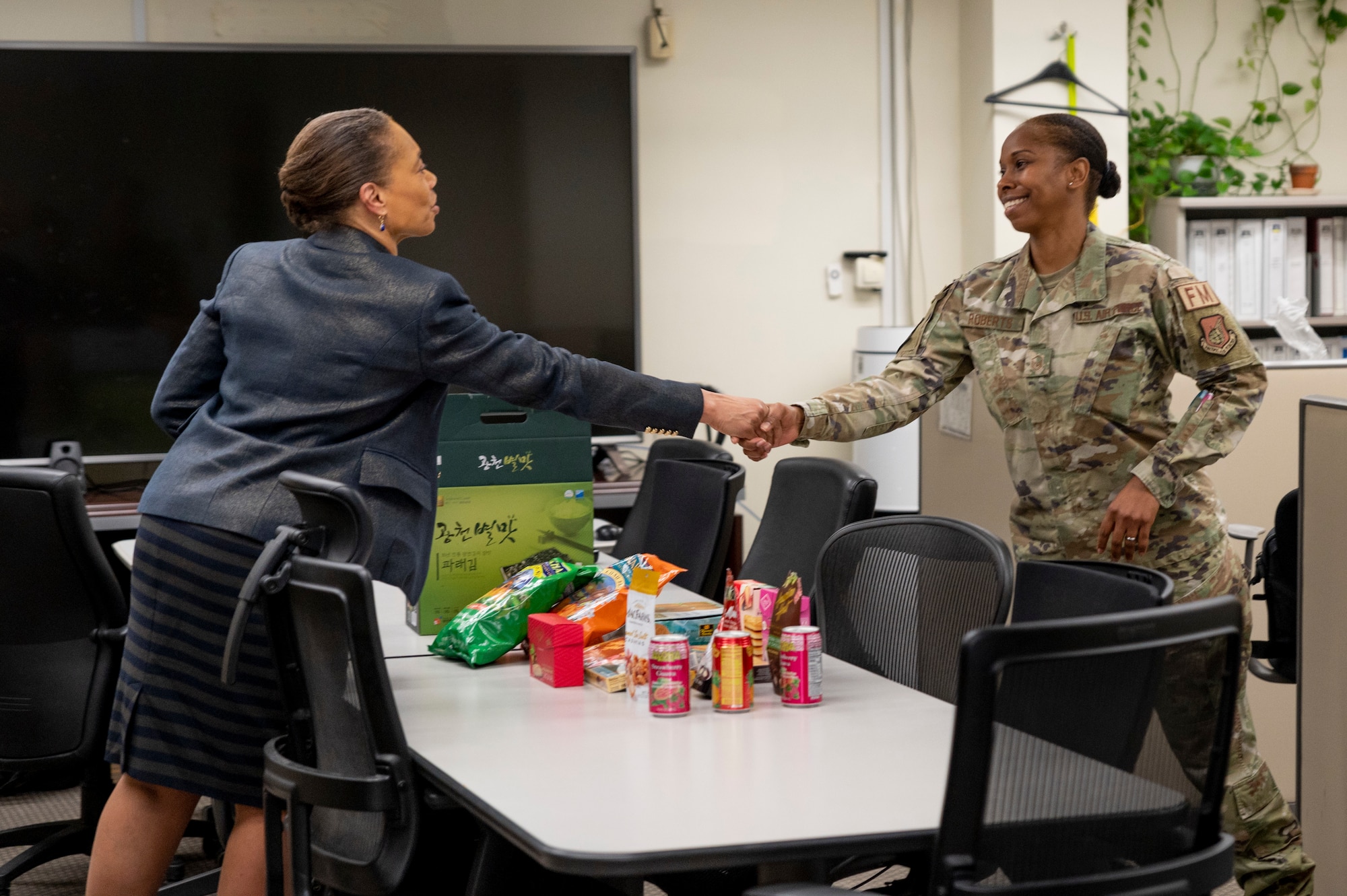 Audrey Davis, Defense Finance and Accounting Service (DFAS) director, coins U.S. Air Force Master Sgt. Simone Roberts, 51st Comptroller Squadron financial analysis flight chief, during her visit to the 51st Fighter Wing at Osan Air Base, Republic of Korea, May 1, 2023.