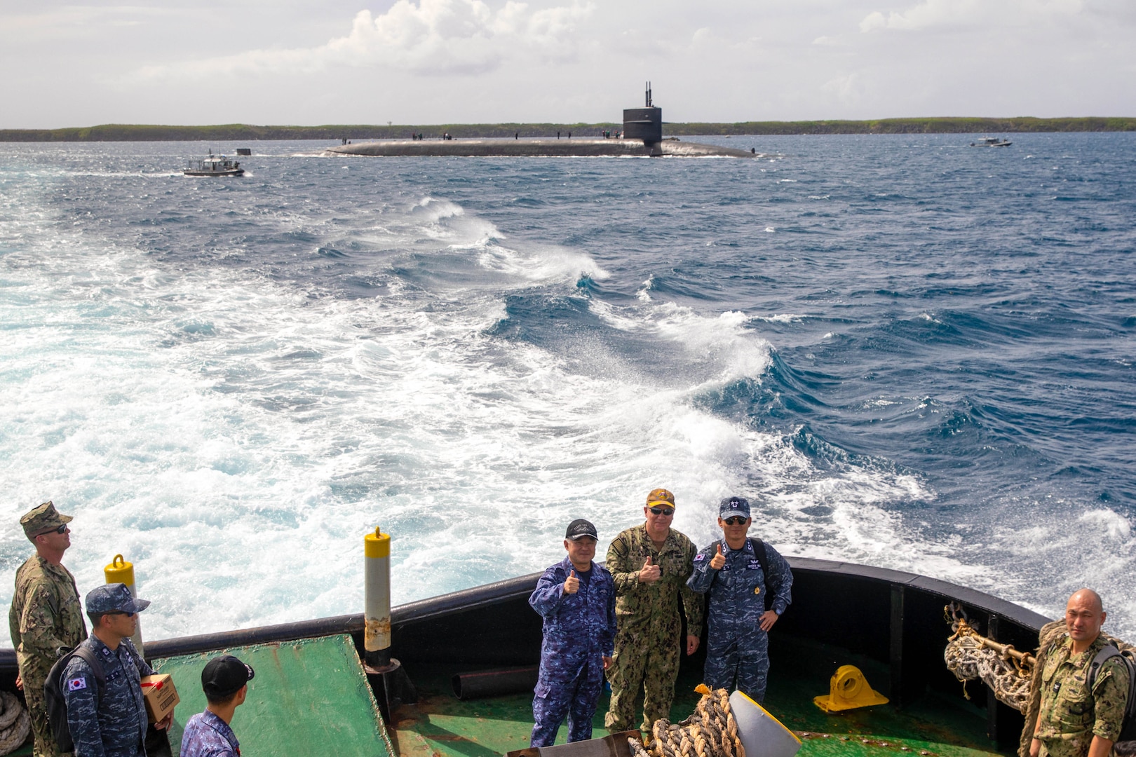 From left, Japan Maritime Self-Defense Force (JMSDF) Vice Adm. Tateki Tawara, commander, Fleet Submarine Force; U.S. Navy Rear Adm. Rick Seif, commander, Submarine Group 7; and Republic of Korea (ROK) Navy Rear Adm. Su Youl Lee, commander, ROK Navy Submarine Force; pose for a photo aboard a tug boat as they approach the Ohio-class ballistic missile submarine USS Maine (SSBN 741), April 18.
