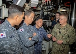 Japan Maritime Self-Defense Force Vice Adm. Tateki Tawara, commander, Fleet Submarine Force, third from the left; speaks with U.S. Navy Rear Adm. Rick Seif, commander, Submarine Group 7, right,; Republic of Korea (ROK) Navy Rear Adm. Su Youl Lee, commander, Submarine Force, second from left; and ROK Navy Lt. Cmdr. Dongkeon Oh, executive officer of ROK Navy submarine ROKS SON WON IL (SS-072), left; during an underway embark aboard the Ohio-class ballistic missile submarine USS Maine (SSBN 741), in vicinity of Guam, April 18. During their time at sea aboard the submarine, the senior leaders were provided tours and demonstrations of the unit’s capabilities, which operates globally under U.S. Strategic Command.