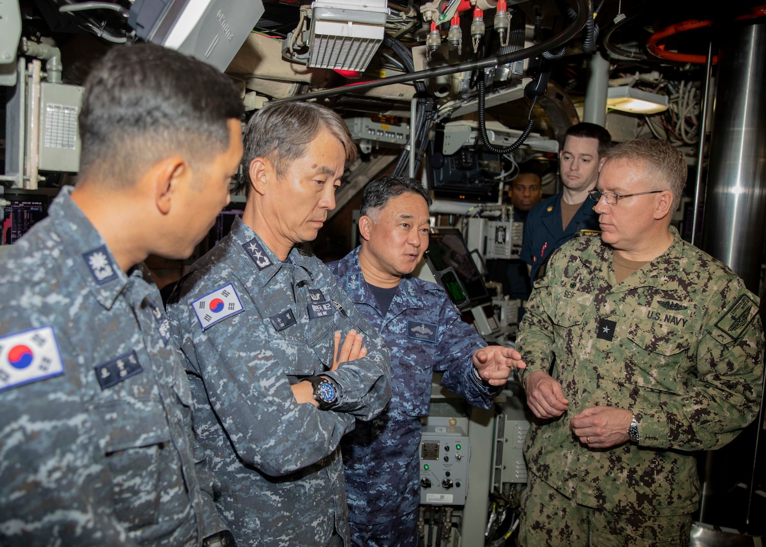 Japan Maritime Self-Defense Force Vice Adm. Tateki Tawara, commander, Fleet Submarine Force, third from the left; speaks with U.S. Navy Rear Adm. Rick Seif, commander, Submarine Group 7, right,; Republic of Korea (ROK) Navy Rear Adm. Su Youl Lee, commander, Submarine Force, second from left; and ROK Navy Lt. Cmdr. Dongkeon Oh, executive officer of ROK Navy submarine ROKS SON WON IL (SS-072), left; during an underway embark aboard the Ohio-class ballistic missile submarine USS Maine (SSBN 741), in vicinity of Guam, April 18. During their time at sea aboard the submarine, the senior leaders were provided tours and demonstrations of the unit’s capabilities, which operates globally under U.S. Strategic Command.