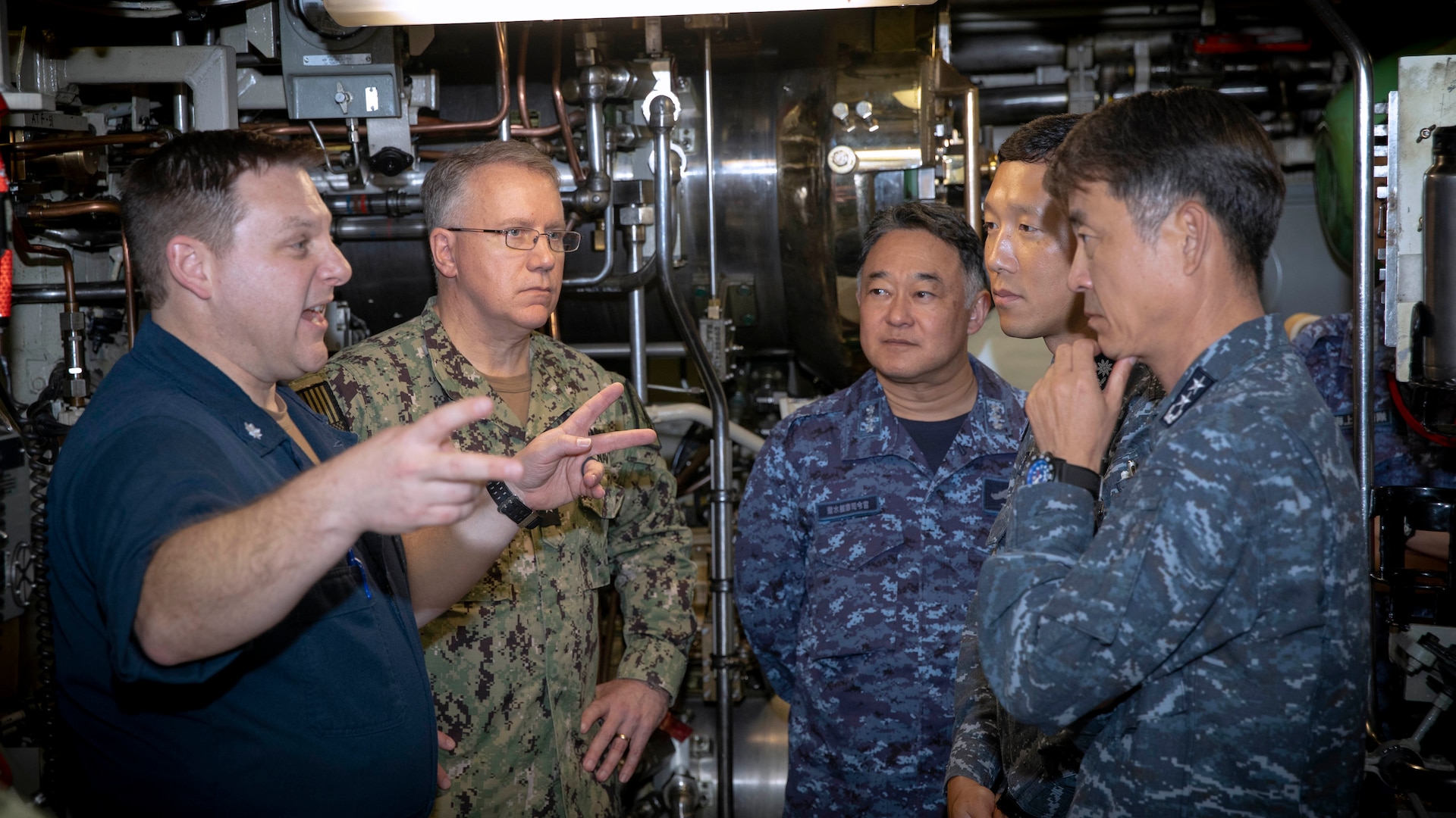 U.S. Navy Cmdr. Travis Wood, commanding officer of Ohio-class ballistic-missile submarine USS Maine (SSBN 741), Gold Crew, left; speaks with U.S. Navy Rear Adm. Rick Seif, commander, Submarine Group 7, second from left; Japan Maritime Self-Defense Force Vice Adm. Tateki Tawara, commander, Fleet Submarine Force, center; Republic of Korea (ROK) Navy Rear Adm. Su Youl Lee, commander, Submarine Force, far right; and ROK Navy Lt. Cmdr. Dongkeon Oh, executive officer of ROK Navy submarine ROKS SON WON IL (SS-072); during an underway embark in vicinity of Guam aboard Maine, April 18. During their time at sea aboard the submarine, the senior leaders were provided tours and demonstrations of the unit’s capabilities, which operates globally under U.S. Strategic Command.