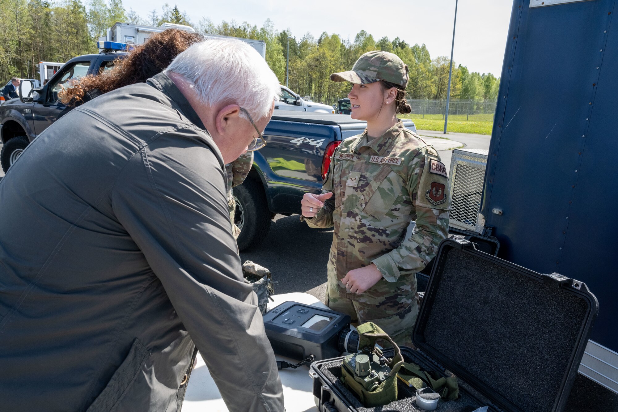 U.S. Air Force Airman 1st Class Rachel McCommon, 52nd Civil Engineer Squadron emergency management journeyman, demonstrates the abilities of a 908 device to German local nationals