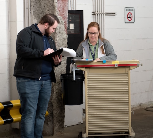 Two personnel confirm a checklist of hazardous waste.