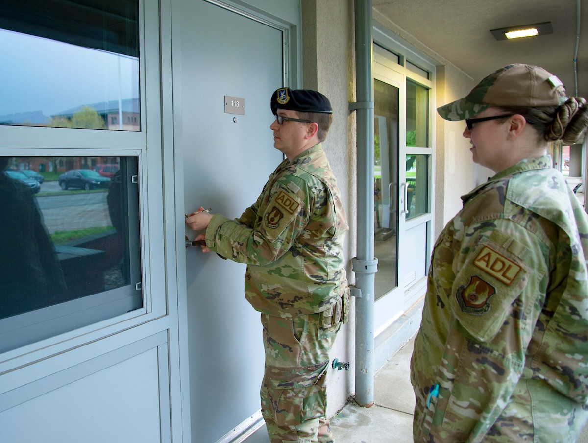 Two Airmen Dorm Leaders prepare to inspect a room.