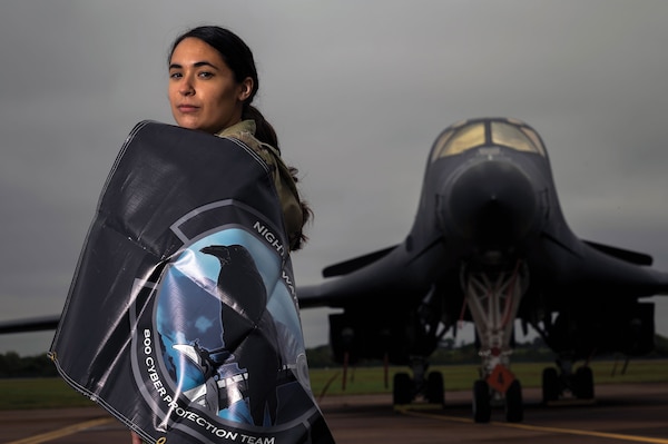 Cyber crew lead assigned to 800th Cyber Protection Team,
Joint Force Headquarters Cyber–Air Force, poses for photo
in front of 9th Expeditionary Bomb Squadron B-1B Lancer at
Royal Air Force Fairford, United Kingdom, October 8, 2021
(U.S. Air Force/Colin Hollowell)