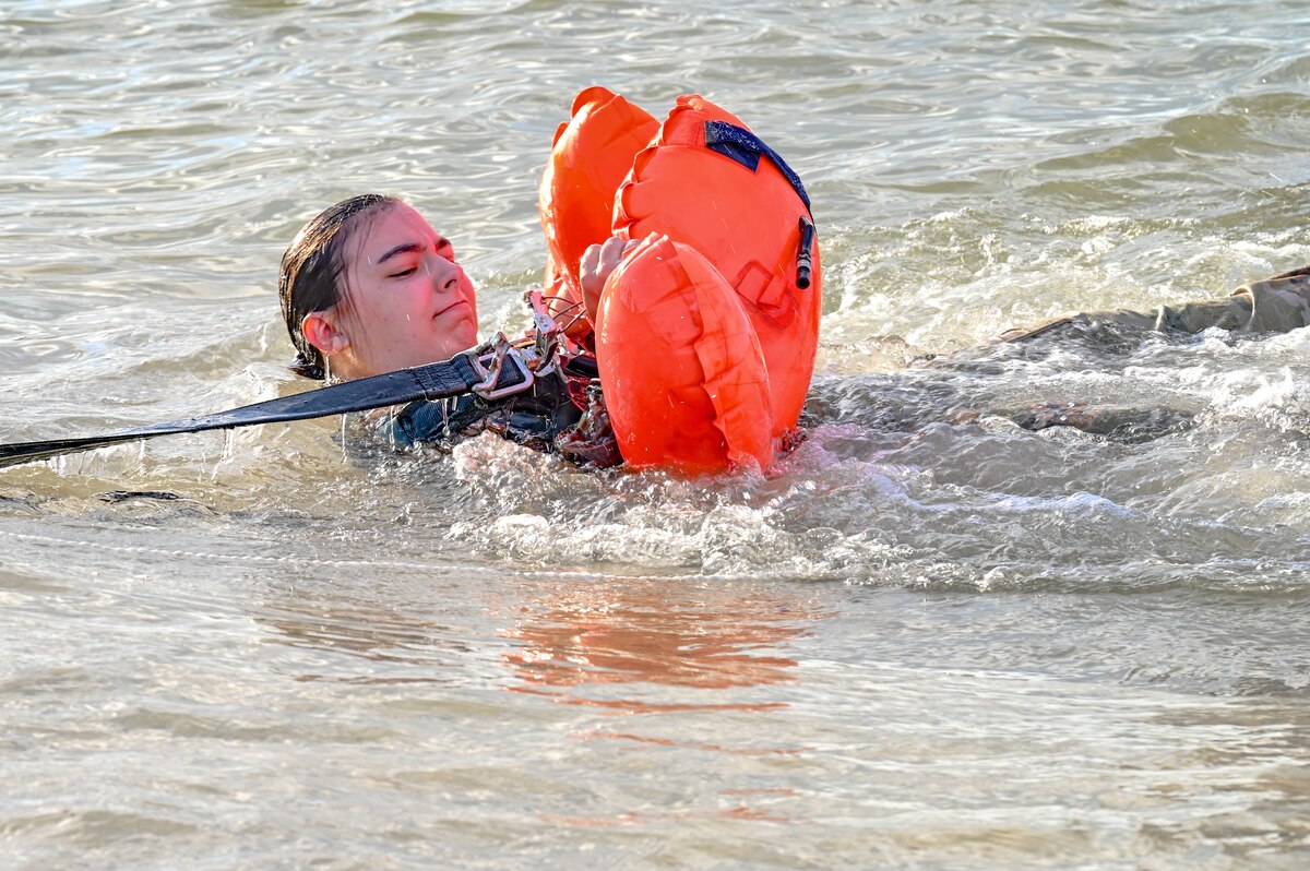 Senior Airman Chloe Lenkner, a loadmaster assigned to the 757th Airlift Squadron, gets pulled through the water during water survival training on April 19, 2023, at Naval Air Station Key West, Florida.