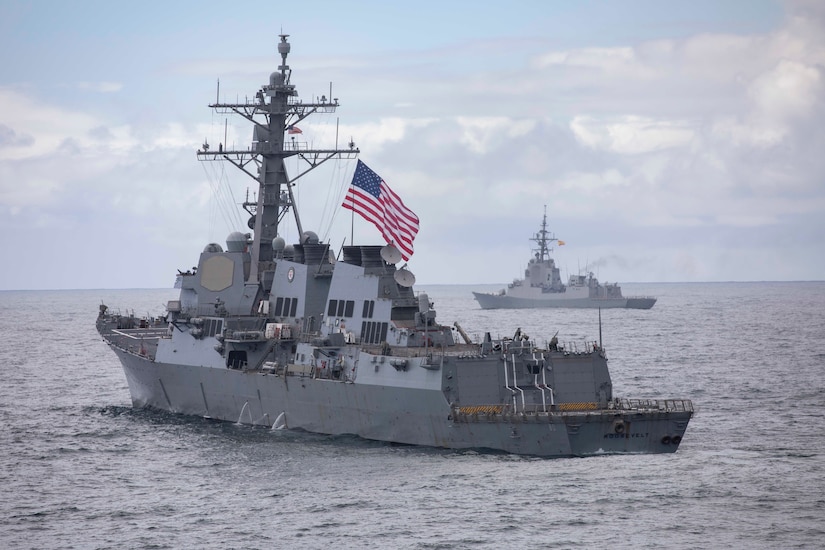 Two large ships move across the ocean.