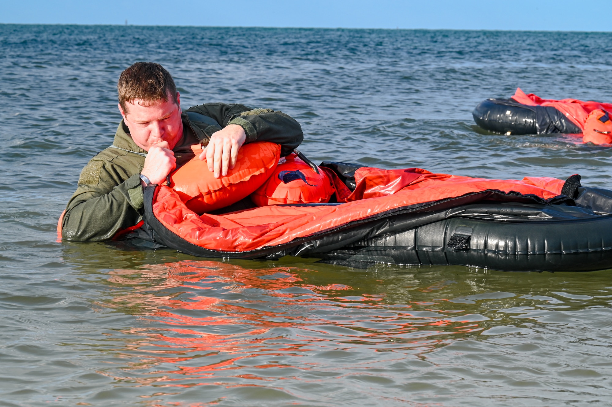 Maj. Tyler McNeely, the chief of tactics assigned to the 910th Operations Support Squadron, inflates a one-person life raft during water survival training on April 19, 2023, at Naval Air Station Key West, Florida.