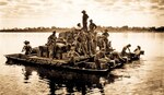 U.S. Army barge, powered by outboard motors, crosses Irrawaddy River near Tigyiang, Burma, with Soldiers, ammunition, and truck, December 30, 1944 (U.S. Army/William Lentz)