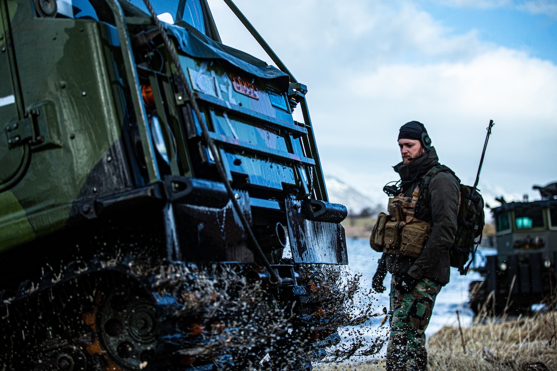 A Korps Marinier with the Royal Netherlands Marine Corps directs BV206 Tracked Terrain Vehicle from a Netherlands Landing Craft Utility during Exercise Cold Response ‘22 in Sandstrand, Norway, March 21, 2022. Exercise Cold Response ‘22 is a biennial Norwegian national readiness and defense exercise that takes place across Norway, with participation from each of its military services, including 26 North Atlantic Treaty Organization allied nations and regional partners. (U.S. Marine Corps photo by Lance Cpl. Meshaq Hylton)