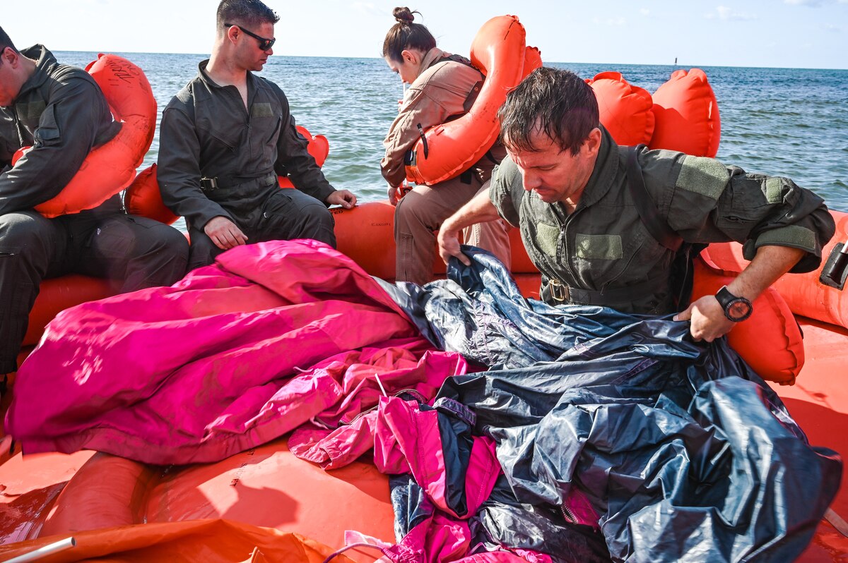 Lt. Col. Chris May, the chief pilot assigned to the 757th Airlift Squadron, unfolds a 20-person life raft canopy during water survival training on April 19, 2023, at Naval Air Station Key West, Florida.