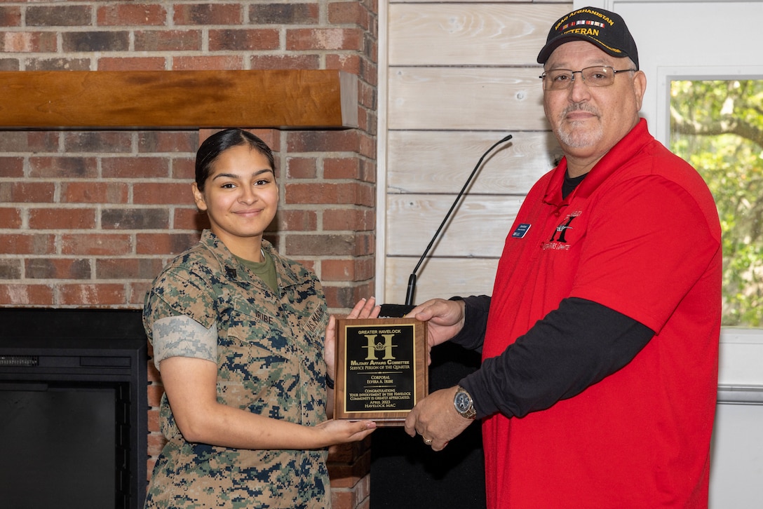 U.S. Marine Corps Cpl. Elvira Iribe, an administrative specialist assigned to Headquarters and Headquarters Squadron, Marine Corps Air Station (MCAS) Cherry Point accepts an award plaque from James Hunter, the president of the Havelock Chamber of Commerce Military Affairs Committee, at the Service Person of the Quarter ceremony, at the Hancock Lodge, MCAS Cherry Point, April 26, 2023. The Havelock Chamber of Commerce Military Affairs Committee honored Iribe for her volunteer work around the installation and in the surrounding community. (U.S. Marine Corps photo by Lance Cpl. Lauralle Walker)