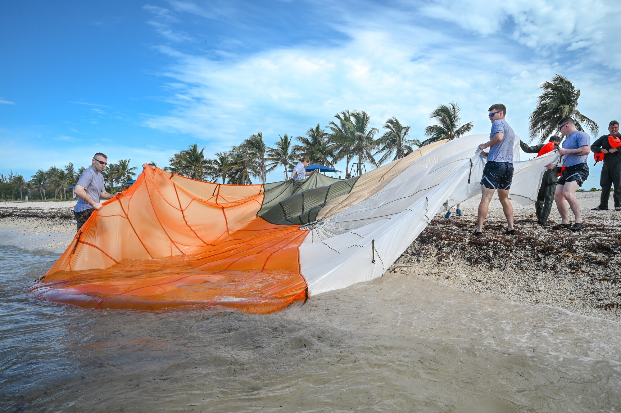 Reserve Citizen Airmen assigned to the 910th Airlift Wing carry a parachute out of the ocean during water survival training on April 19, 2023, at Naval Air Station Key West, Florida.