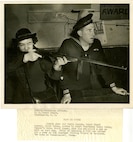 Twenty year old Marie Deppen, Coats Guard seaman, first class, proves to Coast Guardsman Henry Burby, Gunner's Mate, third class, that she can shoot a gun as well as test one.  Prior to becoming a SPAR she worked for a year at the Aberdeen Proving Ground in Maryland.