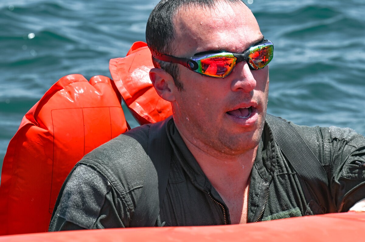 Maj. Nick Bargiband, chief of current operations assigned to the 910th Operations Support Squadron, climbs into a 20-person life raft during water survival training on April 19, 2023, at Naval Station Key West, Florida.