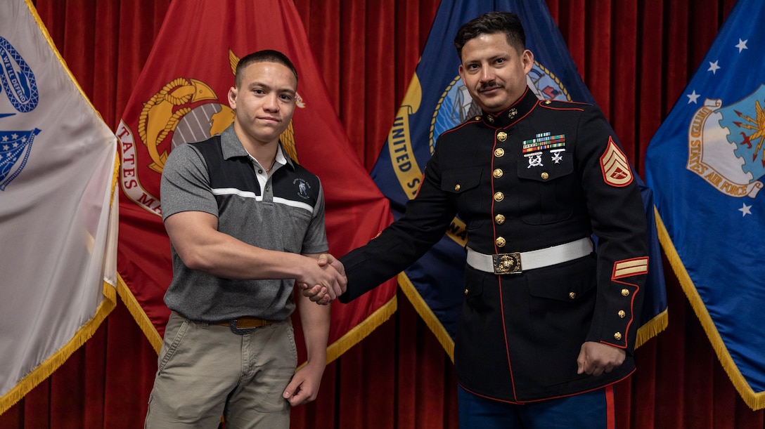 Christian Holmes shakes the hand of his recruiter, Staff Sgt. Salinas of Recruiting Station Chicago after his Oath of Enlistment  ceremony at Chicago's Military Enlistment Processing Station, Chicago, IL, April 22, 2023. Holmes is a graduate of Carmel Catholic High School and is enlisting into the United States Marine Corps in where he will ship to bootcamp sometime this summer in hopes of earning the title, Marine. (U.S. Marine Corps Photo by Sgt. Dalton J. Payne)