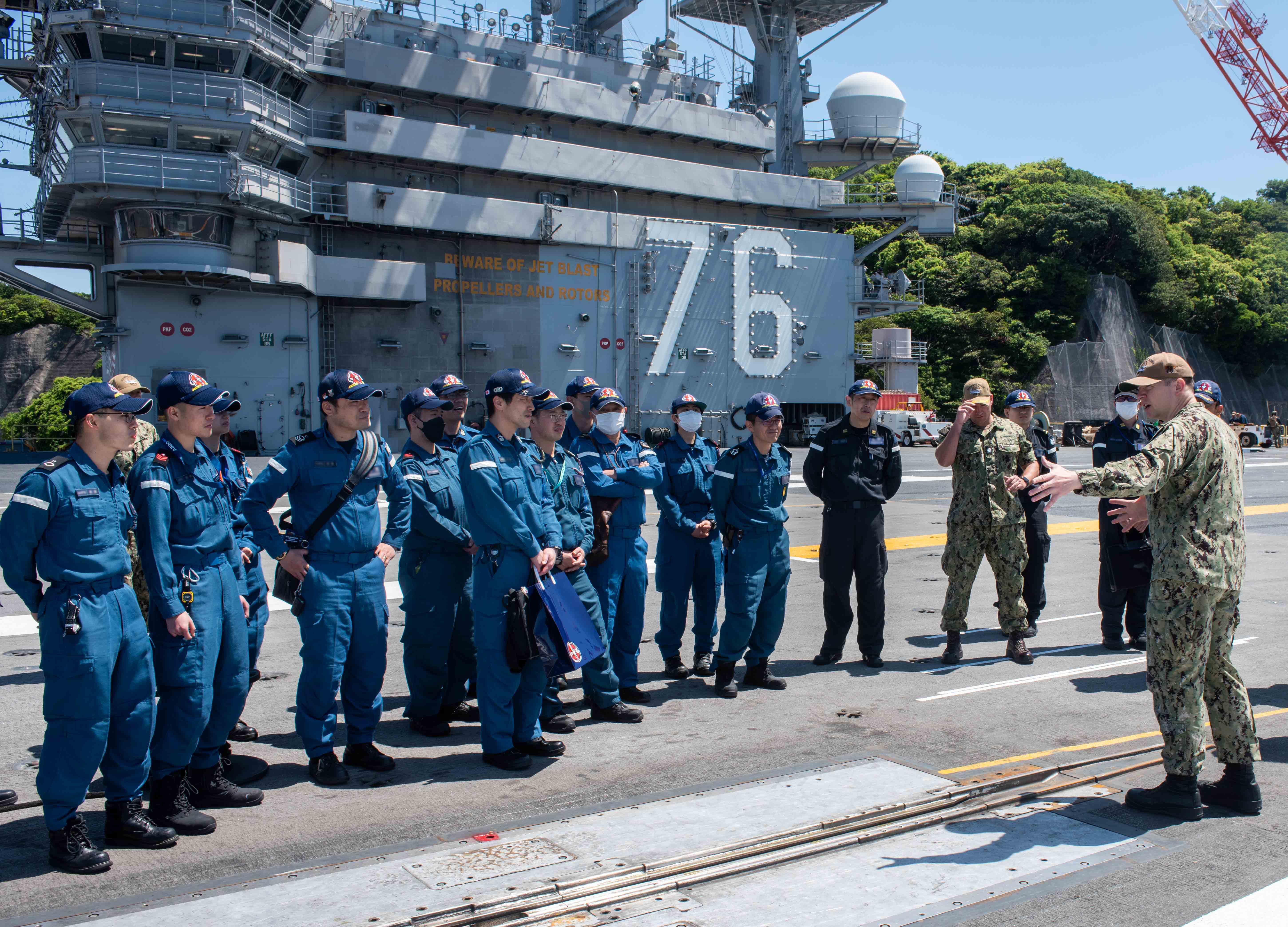Lt. Cmdr. Phillip Chitty gives a tour of USS Ronald Reagan (CVN 76) Japan Maritime Self-Defense Force sailors at Fleet Activities Yokosuka.