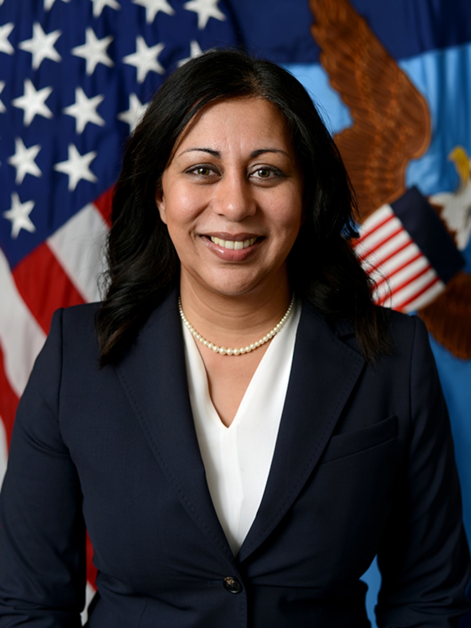 Woman stands in front of flag.