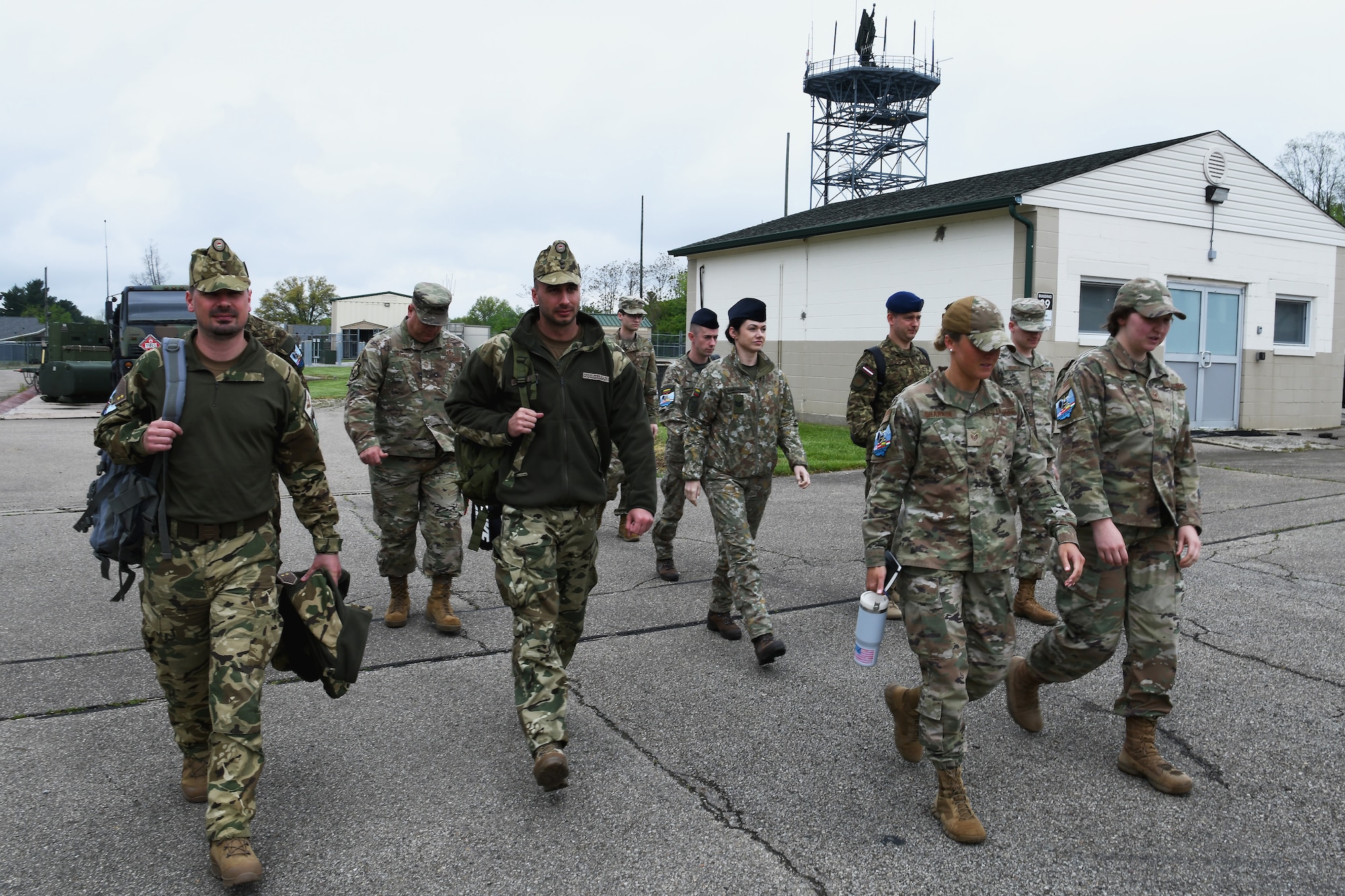 Airmen assigned to the 123rd Air Control Squadron and six service members from Lithuania, Latvia and Hungary walk to a debrief meeting after a training exercise, which included air battle management, ground control intercept, large-force employment and air-to-air combat beyond visual range, on April 28, 2023 in Blue Ash, Ohio. Joint training exercises with international allies and partners increases military readiness and the ability to respond to rapidly changing threats in complex environments. (U.S. Air National Guard photo by Shane Hughes)