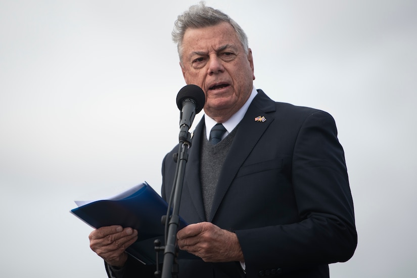 A man speaks in front of a microphone.