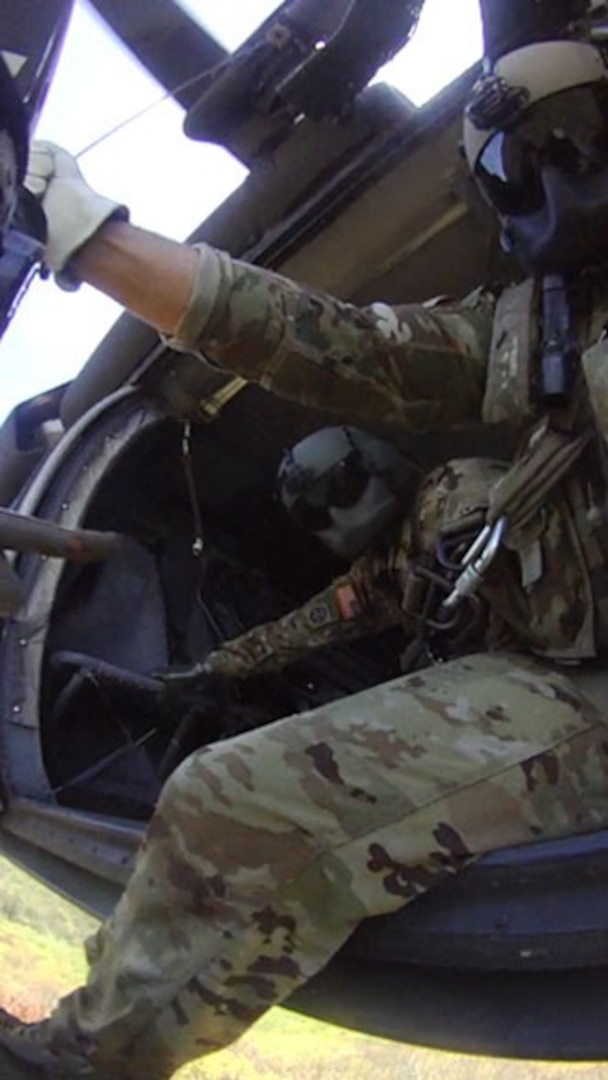 A Tennessee Army National Guard Black Hawk helicopter crew chief, Sgt. Nicholas Kannard, prepares to lower the fight medic, Sgt. 1st Class Tracy Banta, by hoist to begin rescuing an injured hunter in the Cherokee National Forest on May 4.