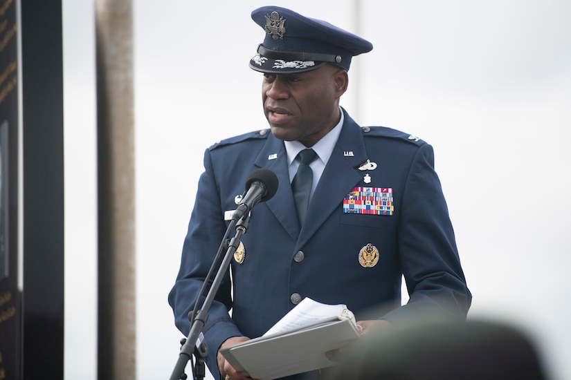 A man in uniform speaks at a lectern.