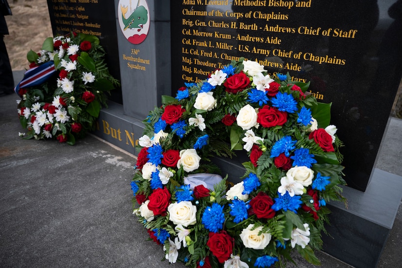 A wreath is on display in front of a monument.