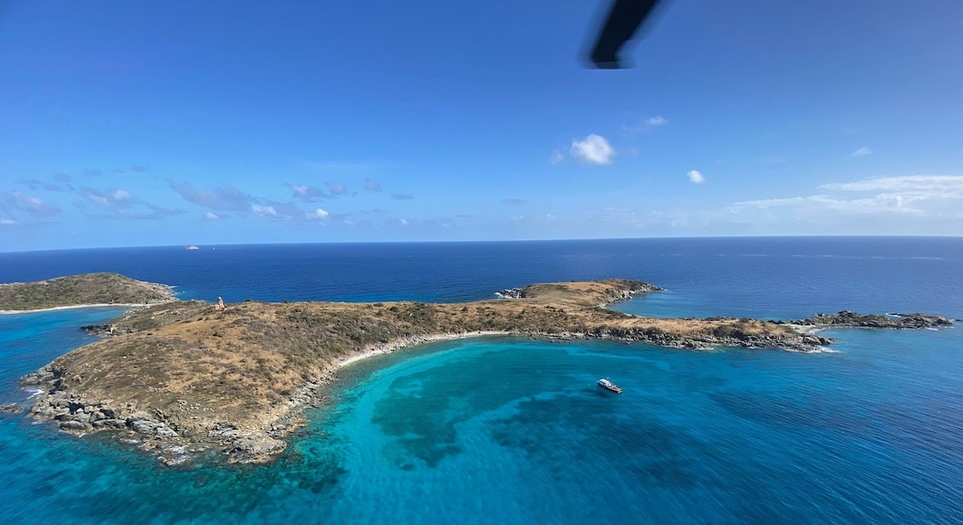 A Coast Guard Air Station Borinquen MH-60T Jayhawk helicopter crew delivers crates with the parts to rebuild an aids to navigation tower light on Buck Island, just off St. Thomas, U.S. Virgin Islands, April 21, 2023. The tower light became operational April 23, 2023, and is assisting maritime traffic seeking to enter Charlotte Amalie or West Gregory Channel in St. Thomas, U.S. Virgin Islands. (U.S. Coast Guard photos by Chief Petty Officer Robert Quinn)