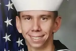 A photo shows a young man wearing a Navy uniform.