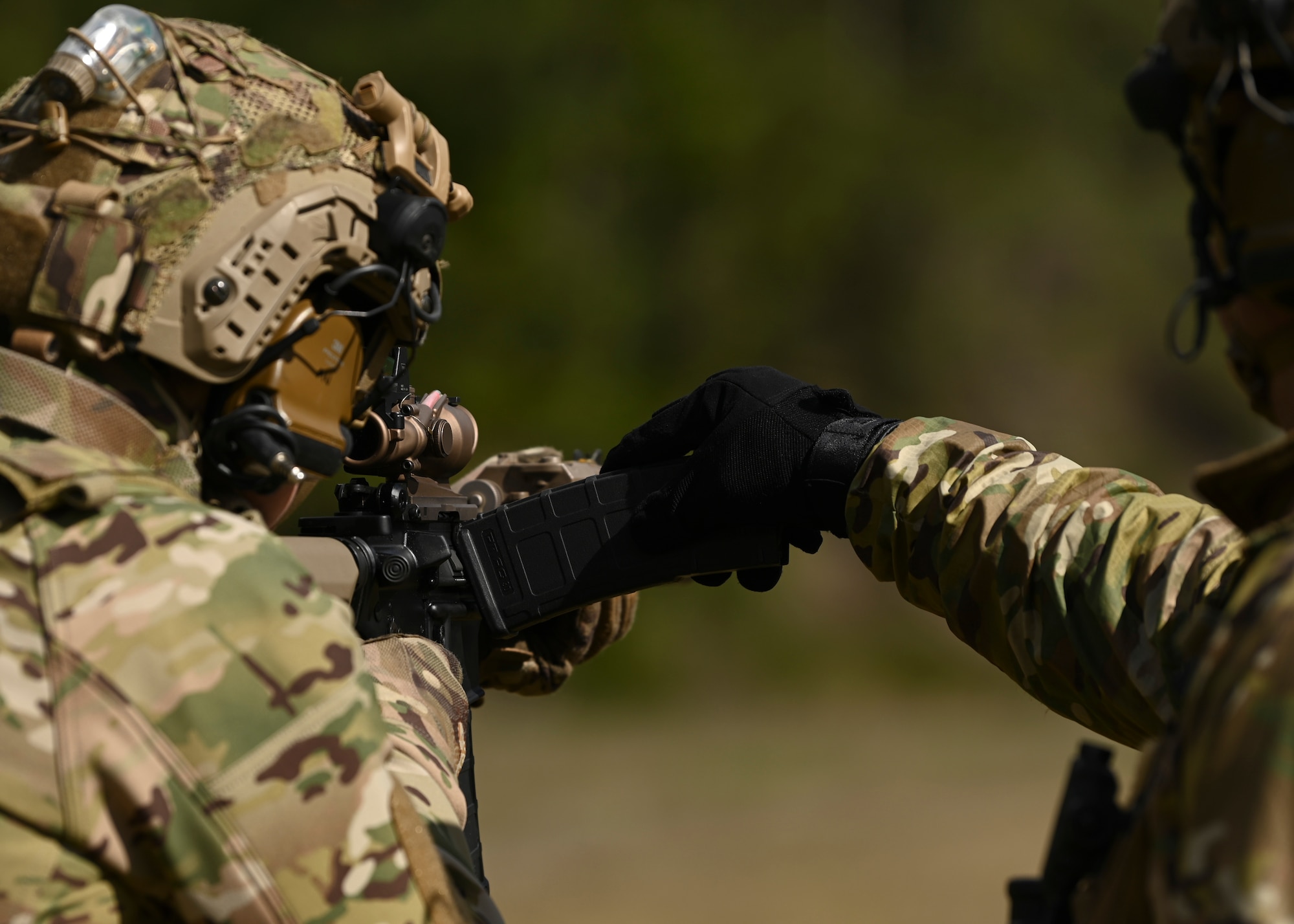 A U.S. Air Force small arms training instructor with the 5th Air Support Operations Squadron initiates a double feed malfunction on an M4 weapon system at Joint Base Lewis-McChord, Washington, April 19, 2023. Multiple times a year, the 5th ASOS holds a basic proficiency training in small arms tactics focused on safely maneuvering with the M4 and M18 weapons. (U.S. Air Force photo by Senior Airman Callie Norton)