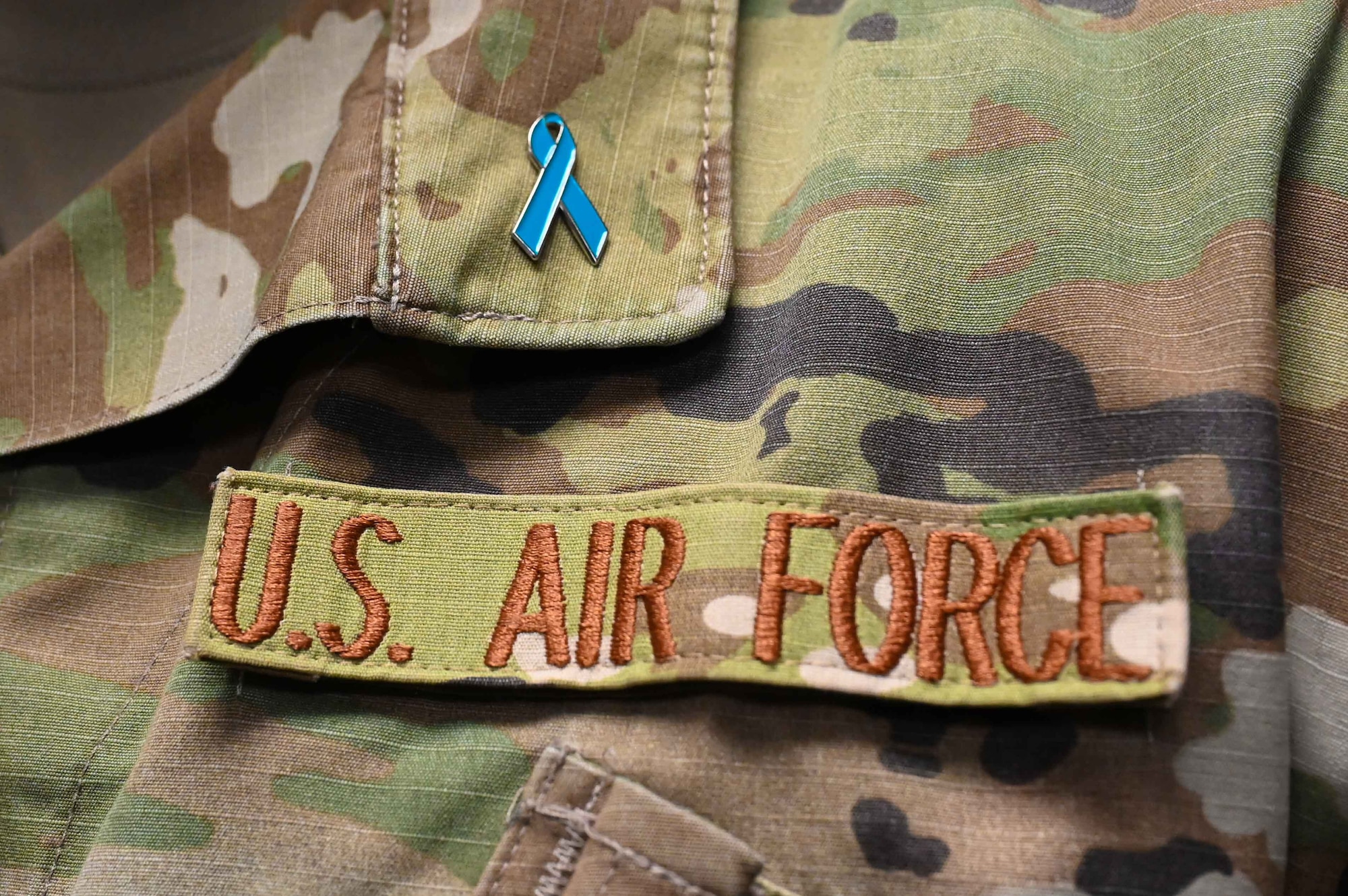 U.S. Air Force Master Sgt. Nathan Allen, 97th Air Mobility Wing public affairs superintendent, shows off the ribbon for “Teal Tuesdays” at Altus Air Force Base, Oklahoma, April 26, 2023. The ribbon is meant to bring awareness to sexual assault victims. (U.S. Air Force photo by Airman1st Class Kari Degraffenreed)