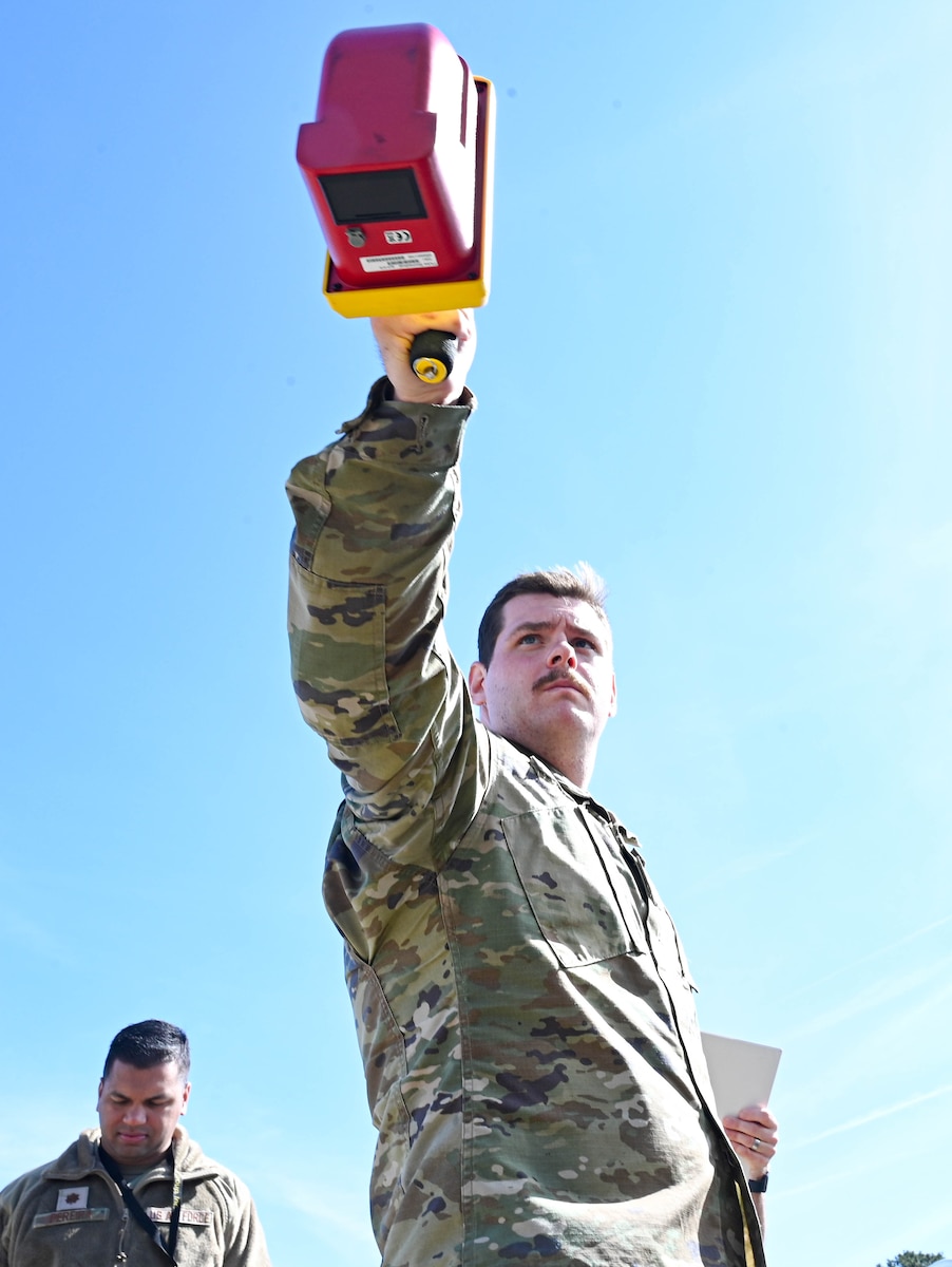 Airman simulates a radiological assessment during a post-nuclear training exercise.