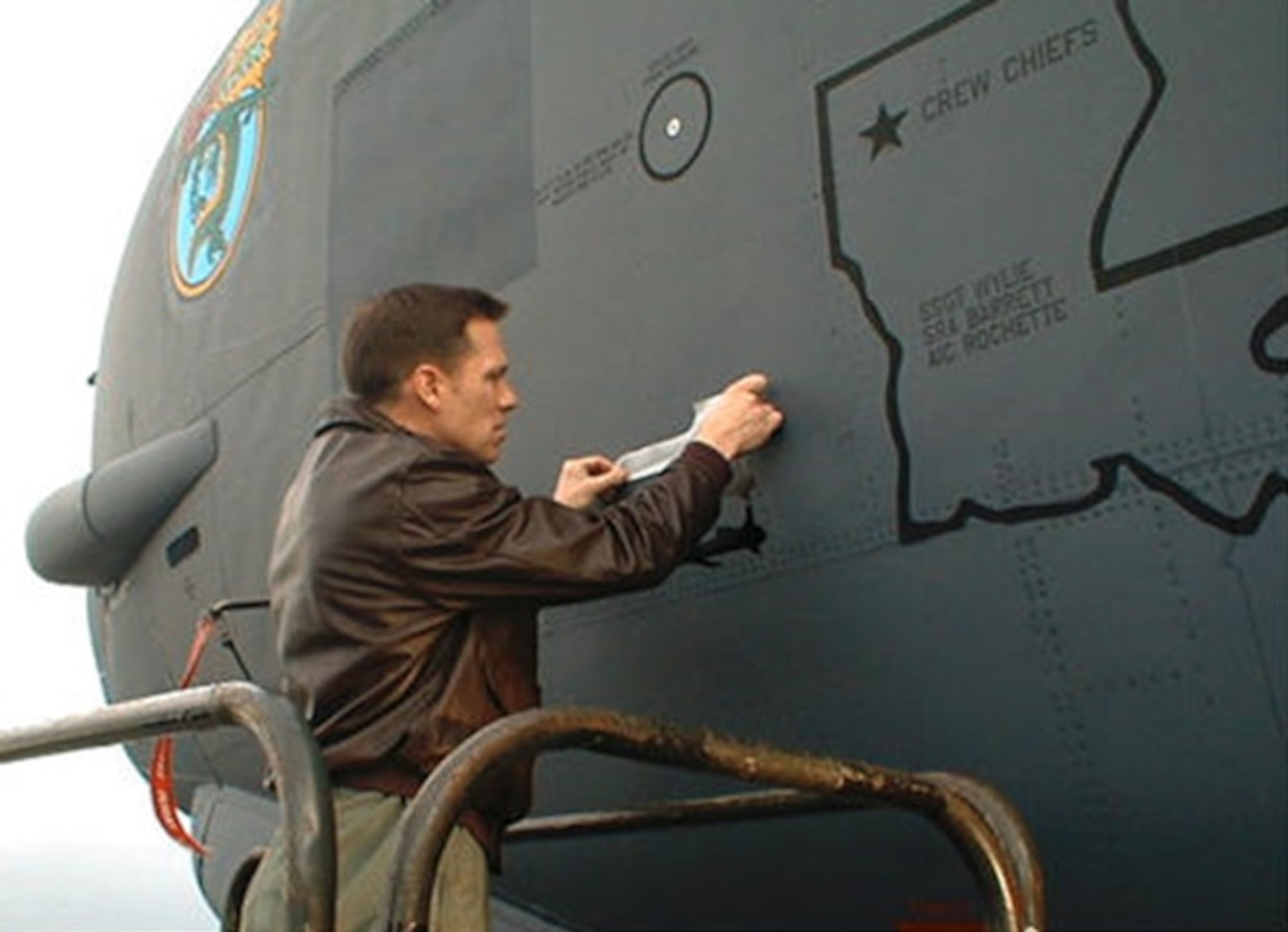 A photo of a pilot marking a plane.