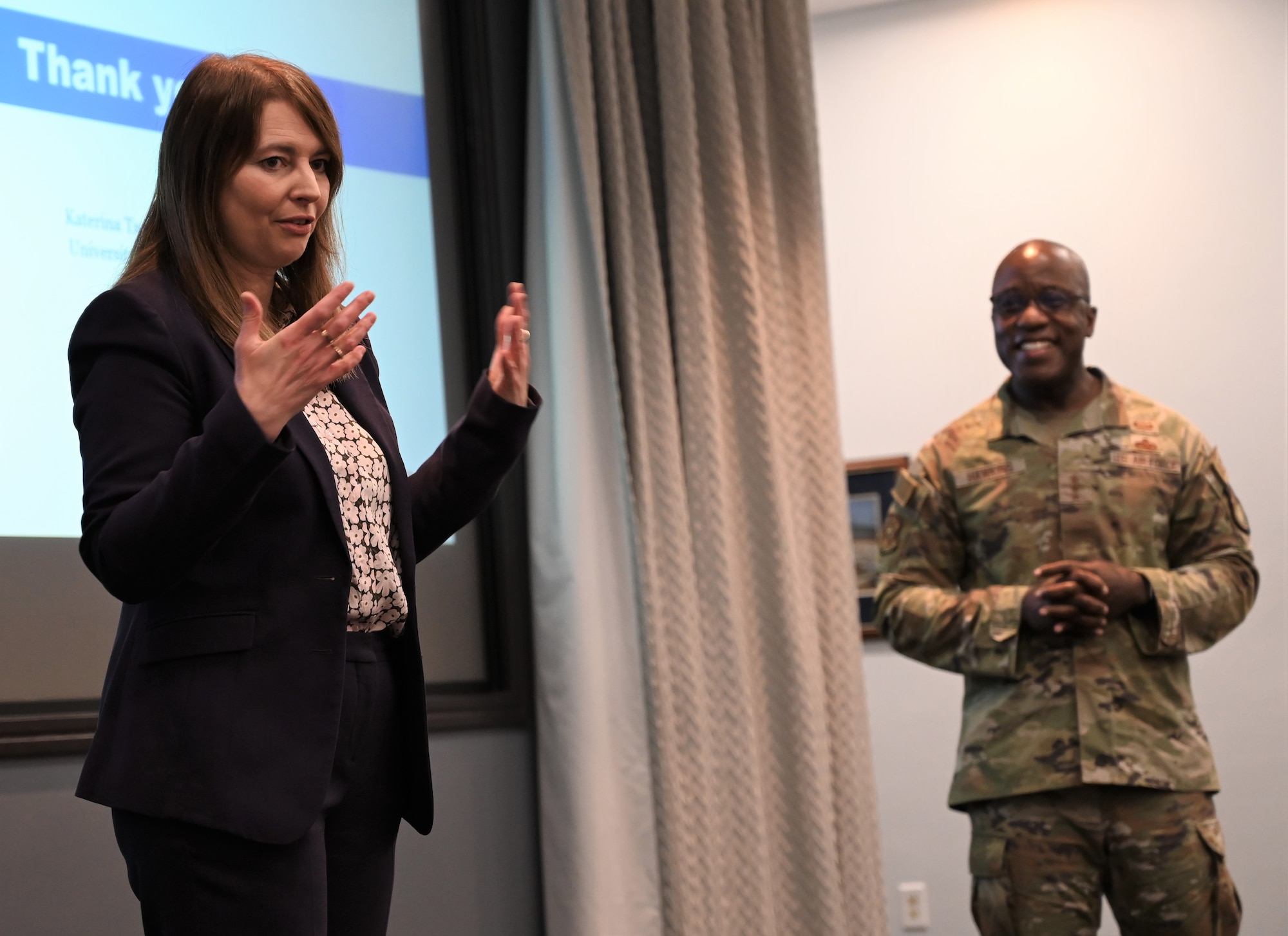 Photo of woman giving presentation on a stage.
