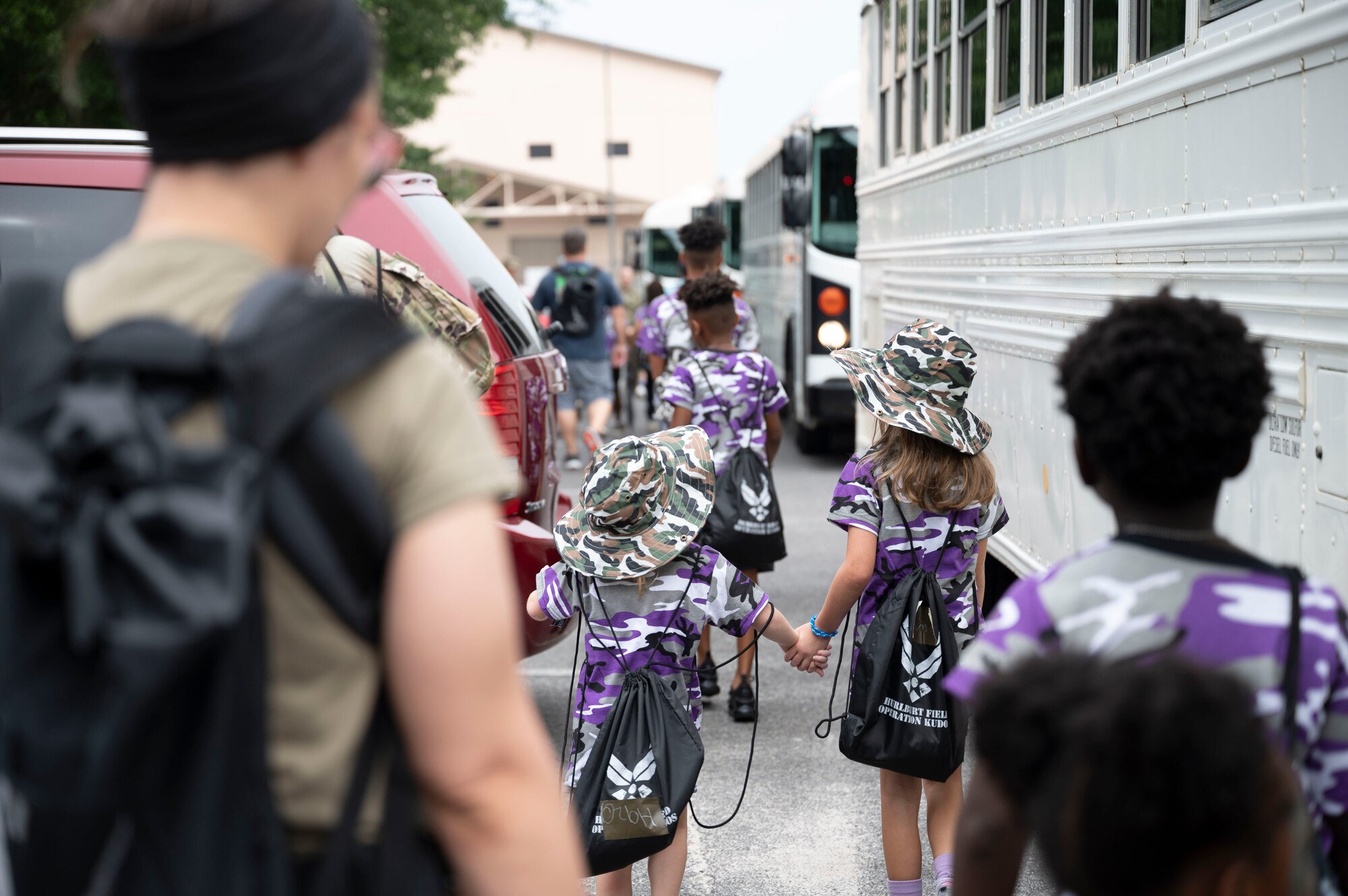 Military children board buses to travel to their “deployed location” during Operation Kids Understanding Deployment Operations at Hurlburt Field, Fla., April 29, 2023.