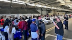 Large group of people gathered in a warehouse to attend a Health and Safety Fair