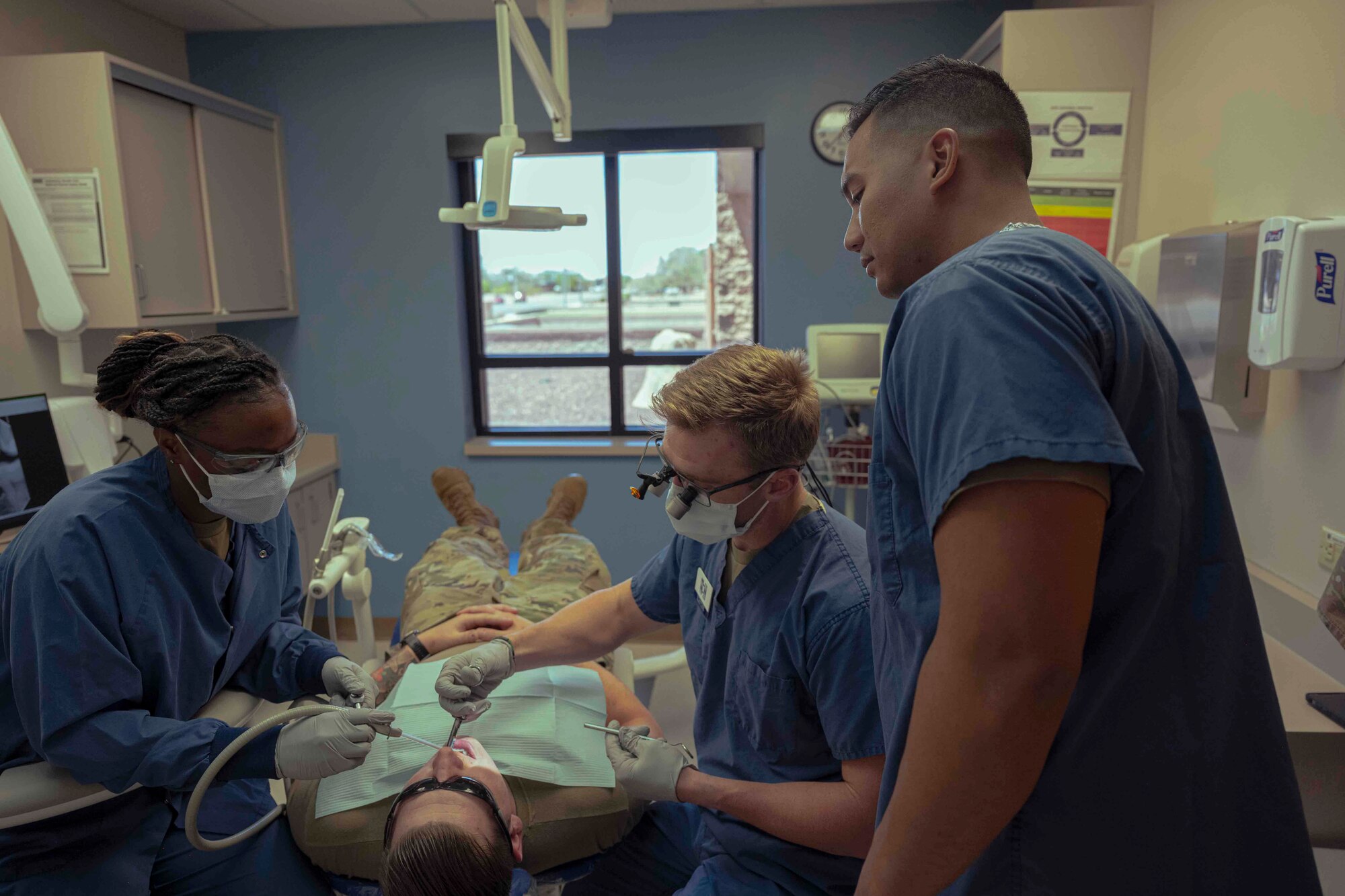 U.S. Air Force Tech. Sgt. Iokepa Garcia, 54th Fighter Group unit training manager, right, observes a dental procedure during a job swap event at Holloman Air Force Base, New Mexico, April 27, 2023. The purpose of the event was for Airmen to go out and shadow other career fields. (U.S. Air Force photo by Senior Airman Antonio Salfran)