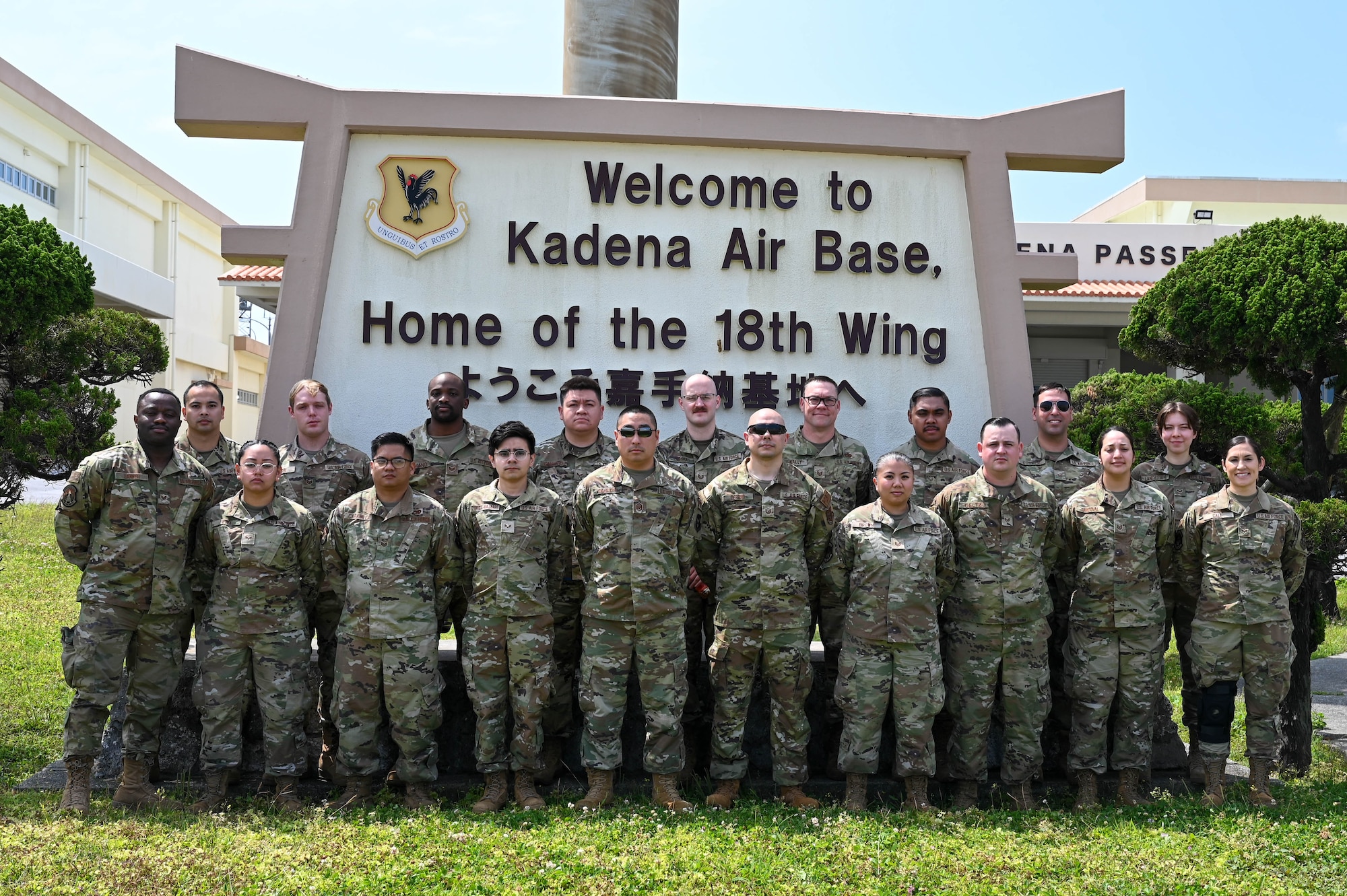 A group photo of airmen in front of the Welcome to Kadena Air Base sign.
