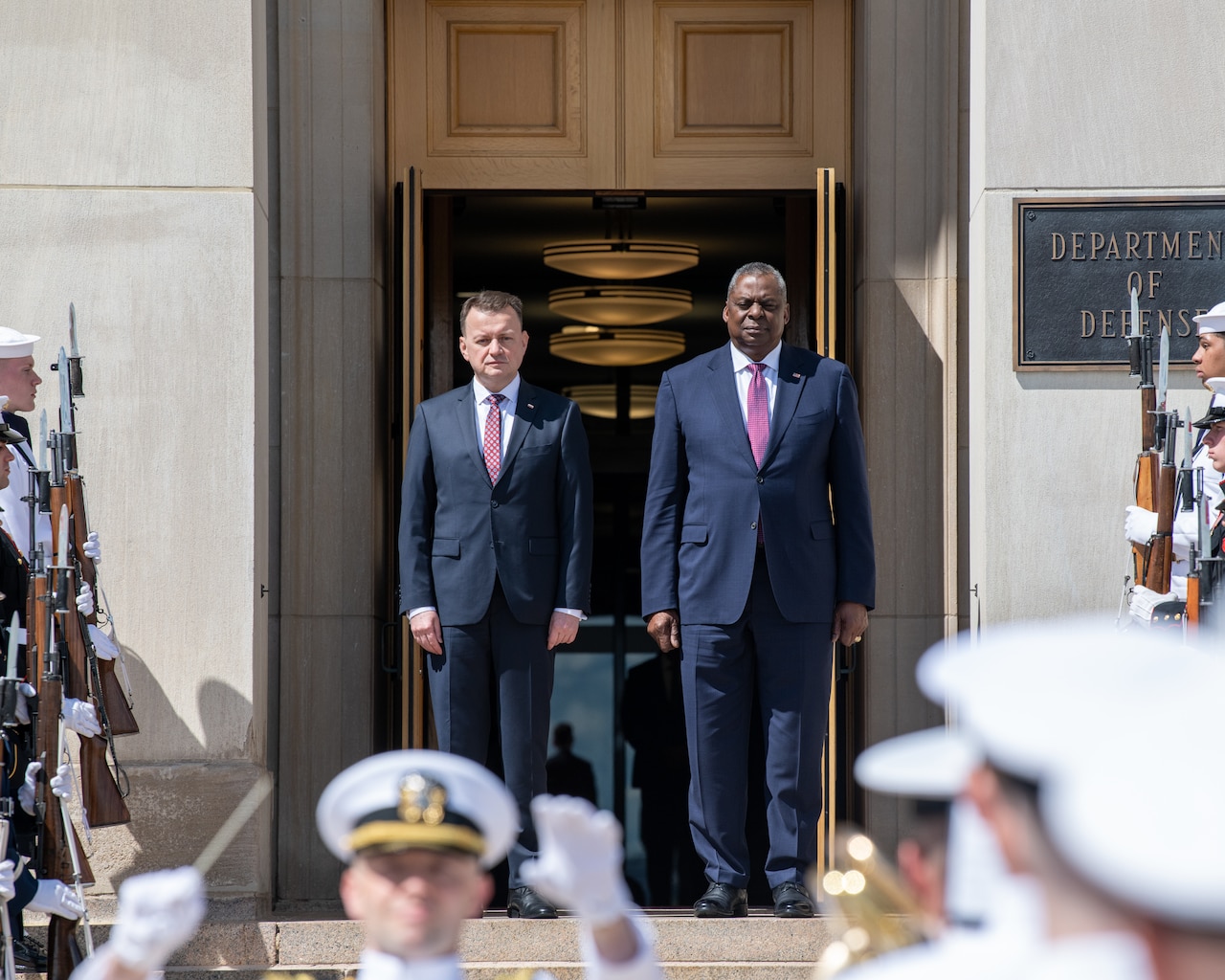 Two men stand on the steps of the Pentagon during a ceremony.