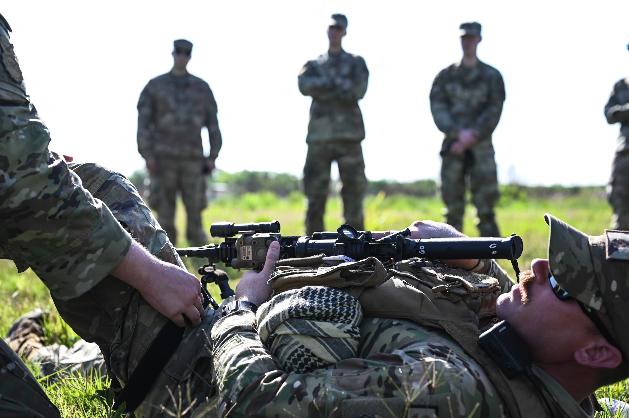 U.S. Air Force Tech. Sgt. Anthony Scharf, 47th Security Forces Squadron non-commissioned officer in charge of plans and programs, lays on the ground while a tourniquet is put on his leg during a training exercise at Laughlin Air Force Base, Texas, on April 28, 2023.