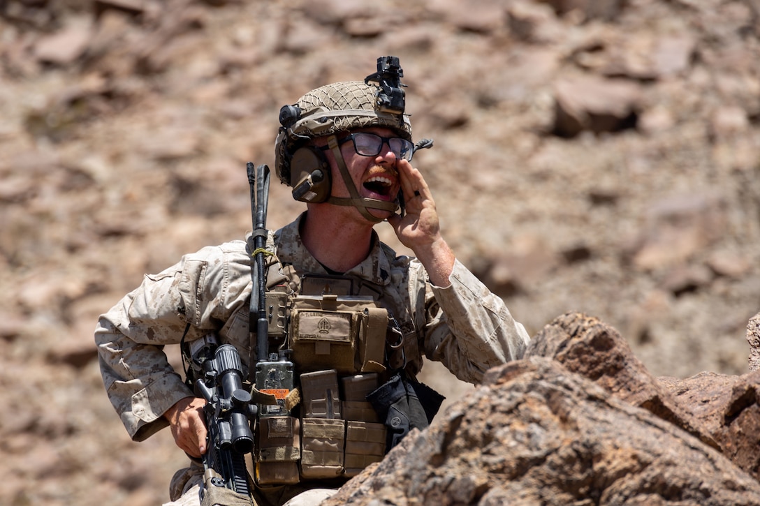 A U.S. Marine squad leader relays information over the radio during a training exercise in the desert