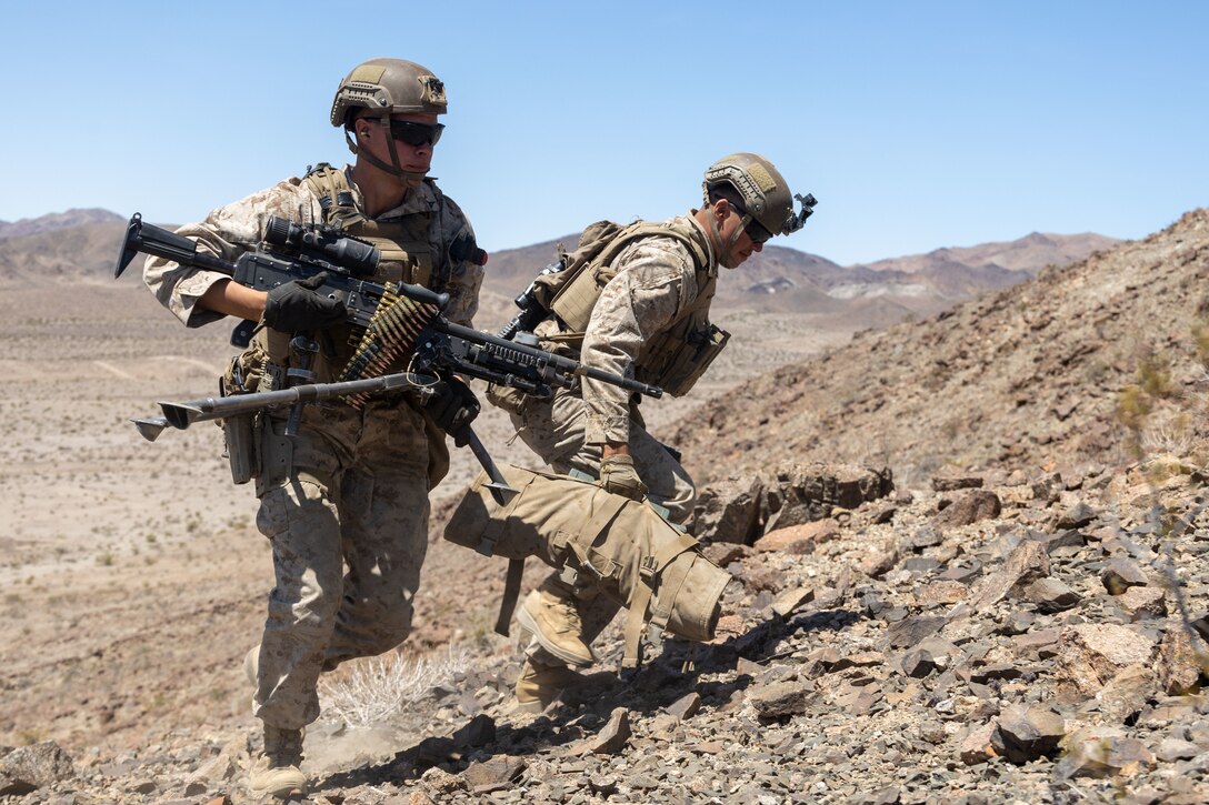 U.S. Marine Corps Lance Cpl. Samuel Sherry, left, and Lance Cpl. Logan Justice, machine gunners with 2nd Battalion, 2nd Marine Regiment, 2nd Marine Division, displace to change firing positions during Marine Air-Ground Task Force Distributed Maneuver Exercise (MDMX), at Marine Corps Air Ground Combat Center, Twentynine Palms, California, April 26, 2023. MDMX is a maneuver exercise that incorporates air, ground, and logistics operations to create favorable conditions for the Joint Force. (U.S. Marine Corps photo by Lance Cpl. Anna Higman)